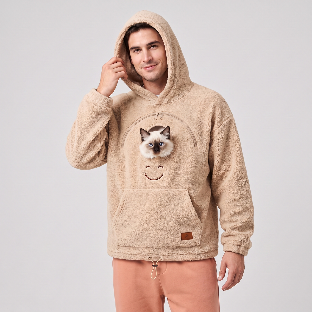 Man wearing the beige CozyPaws pet pocket hoodie with a Ragdoll kitten peeking out of the chest window